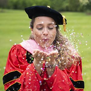 student blowing glitter into the air